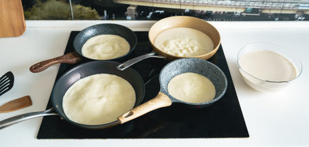 Russia Moscow 14.03.2021 Cooking many big tasty pancakes Lot of pans,oil,pancake dough.Russian traditional national festival winter Maslenitsa holiday week,shrovetide. Man, father cook. Family holiday.の写真素材