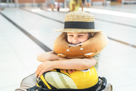 Funny suitcase,bag.Girl in airport terminal. Travel head neck airplane pillow.Boarding to flight.Family vacation travel.Luggage baggage check in arrival departure hall.Summer sea journey.Holiday trip.の写真素材