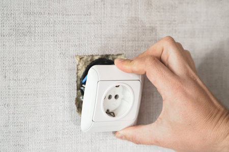 Dangerous bad, broken socket, plug in bathroom, falling out of wall. Outlet installation in old apartment. Poor electrical wire,repair.Terrible do-it-yourself repairmen.Short circuit risk,electric shock.の写真素材