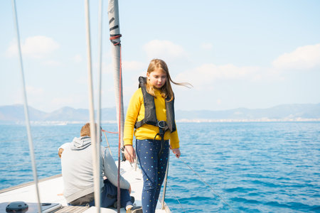 Voyage sail on sport sea luxury yacht. Yachting family summer vacation cruise. Children, sailor kid girl sailing in little safe life jacket. ocean ship boa travel. Enjoy trip on sailboat front deck.の写真素材