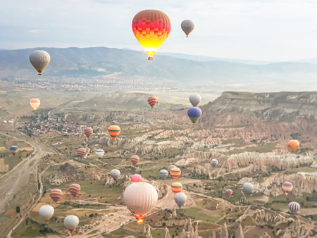 Process of launching many colored beautiful balloons into the air in Cappadocia in mountains early at dawn. Filling balloon with hot air from burner, preparing basket. Excursion,flight for tourists above.の写真素材