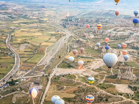 Process of launching many colored beautiful balloons into the air in Cappadocia in mountains early at dawn. Filling balloon with hot air from burner, preparing basket. Excursion,flight for tourists above.の写真素材