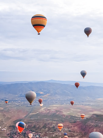 Process of launching many colored beautiful balloons into the air in Cappadocia in mountains early at dawn. Filling balloon with hot air from burner, preparing basket. Excursion,flight for tourists above.の写真素材