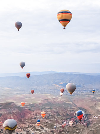 Process of launching many colored beautiful balloons into the air in Cappadocia in mountains early at dawn. Filling balloon with hot air from burner, preparing basket. Excursion,flight for tourists above.の写真素材