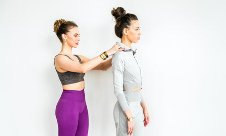 Exercises for posture, smooth straight back, spine. Slim woman training with yoga coach. Private lessons with personal trainer, fitness instructor. Workout, exercises in fitness gym.の写真素材