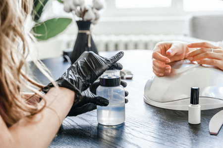 Professional master manicurist at beauty salon. Manicure service, hands treatments, procedures for nails, fingers. Multi-colored nail polish, samples palette, tattoos, cuticle oil, gel uv lamp,gloves.の写真素材