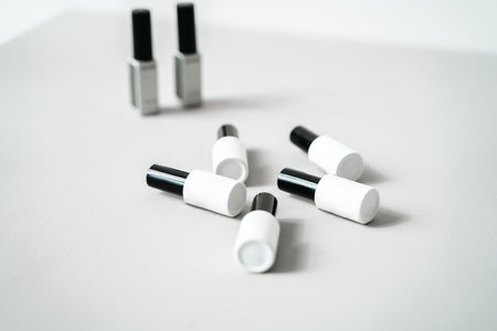 Black bottles with samples of nail polishes on white background. Professional master manicurist at beauty salon. Manicure service, hands treatments, fingers procedures.の写真素材