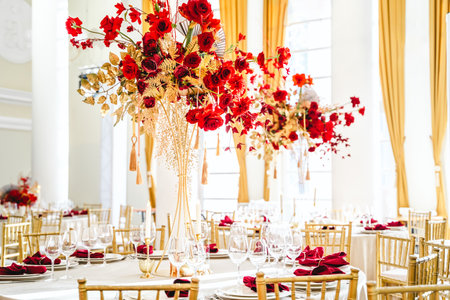 Floral arrangement, festive bouquet, table decoration for Chinese New Year party celebration in restaurant. Traditional red gold color decor. Roses,poppies,fans,candles,tassels. Chinese lunar calendar.の写真素材