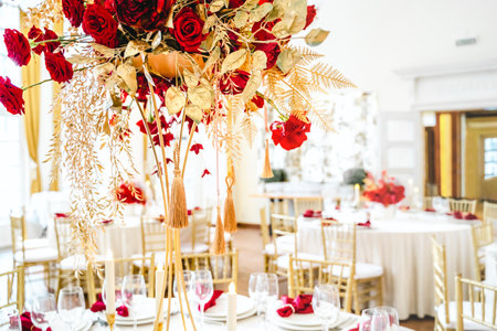 Floral arrangement, festive bouquet, table decoration for Chinese New Year party celebration in restaurant. Traditional red gold color decor. Roses,poppies,fans,candles,tassels. Chinese lunar calendar.の写真素材