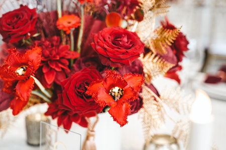 Red gold golden color decor, floral arrangement. Festive bouquet, table decoration. Traditional Chinese New Year party restaurant celebration. Roses,poppies,fan,candles,tassels.Chinese lunar calendar.の写真素材