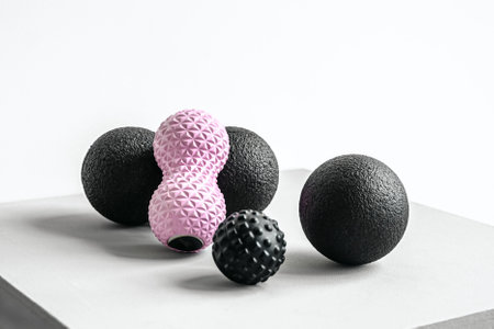 Rubber foam pink peanut roller, black massage ball. Yoga, fitness equipment. Centimeter tape for measuring waist volume. Stretching, pilates accessories. Home workout sport exercises for weight loss.の写真素材