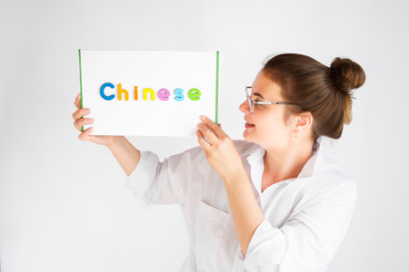 Learning Chinese educational courses. Native tutor, woman teacher in glasses with magnetic sign in hands. Study foreign language in online school. Speaking, reading, writing, linguistic knowledge skills.の写真素材