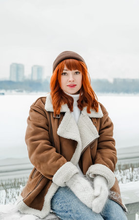 Love romantic couple love story. Brutal bearded man, bright red-haired girl woman in winter park....