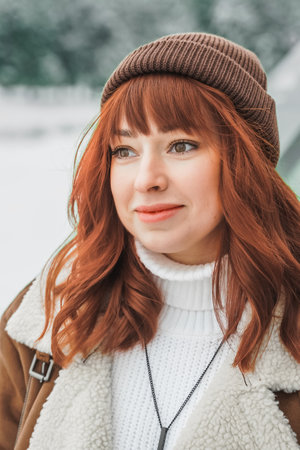 Love romantic couple love story. Brutal bearded man, bright red-haired girl woman in winter park....