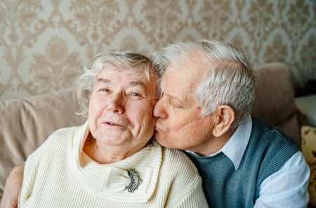 Elderly senior romantic love couple. Old retired man woman together. Aged husband wife in cozy home sweater.Elder hugging kissing people pensioner.Happy family longevity.Tender feelings relationships.の写真素材