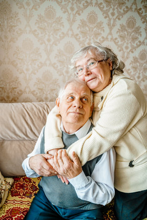 Elderly senior romantic love couple. Old retired man woman together. Aged husband wife in cozy home sweater.Elder hugging kissing people pensioner.Happy family longevity.Tender feelings relationships.の写真素材