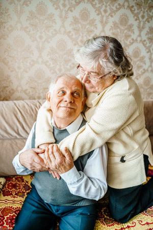 Elderly senior romantic love couple. Old retired man woman together. Aged husband wife in cozy home sweater.Elder hugging kissing people pensioner.Happy family longevity.Tender feelings relationships.の写真素材