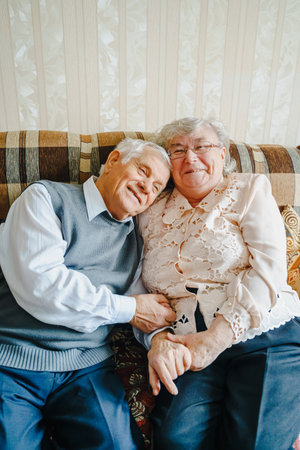Elderly senior romantic love couple. Old retired man woman together. Aged husband wife in cozy home sweater.Elder hugging kissing people pensioner.Happy family longevity.Tender feelings relationships.の写真素材
