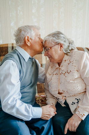 Elderly senior romantic love couple. Old retired man woman together. Aged husband wife in cozy home sweater.Elder hugging kissing people pensioner.Happy family longevity.Tender feelings relationships.の写真素材