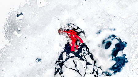 Aerial view of two people ice floating on icy water in bright red survival suits. Arctic frozen landscape. Extreme adventure, ice diving, cold water survival, winter expedition. Fun, outdoor activity.の写真素材