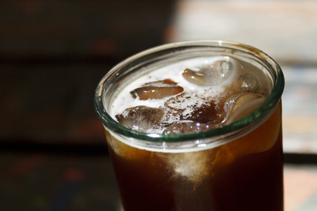 Ice coffee on the wooden background