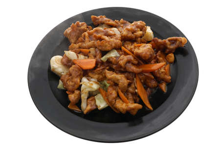 Chinese food. Stir fried Chichen in soya sauce and vegetables in black plate isolated on white. Closeup.の写真素材