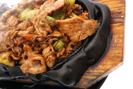 Chinese food. Fried chicken terrine with vegetables in black plate isolated on white. Closeup.の写真素材