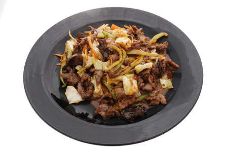 Chinese food. Hot veal in sweet and sour sauce in black plate isolated on white. Closeup.の写真素材
