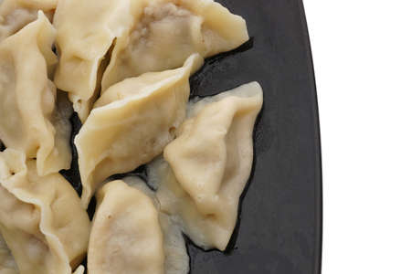 Chinese food. Boiled dumplings with pork and vegetables in black plate isolated on white. Closeup.の写真素材