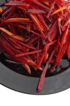 Chinese food. Red beet and carrot salad in black plate isolated on white. Closeup.の写真素材