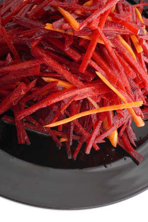 Chinese food. Red beet and carrot salad in black plate isolated on white. Closeup.の写真素材
