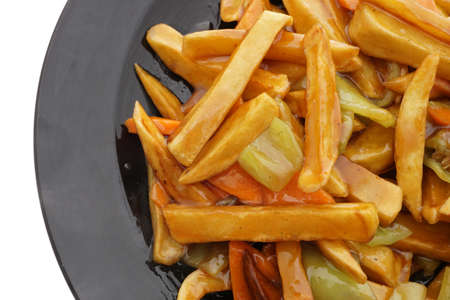Chinese food. Fried potato chips in sauce in black plate isolated on white. Closeup.