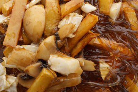Chinese food. Fried potato chips with mushrooms. Closeup.