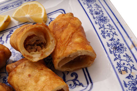 Chinese food. Meat and vegetable spring rolls in white plate isolated on white. Closeup.の写真素材