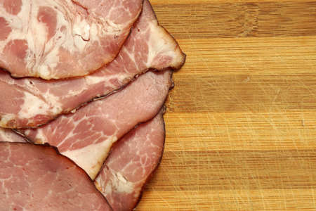 Sliced pork ham on wooden background. close-upの写真素材