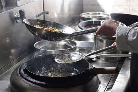 Close up of working chef preparing chinese food, Food frying in wok pan. Sale and food concept の写真素材