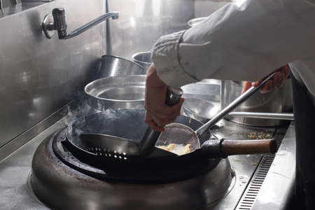 Close up of working chef preparing chinese food, Food frying in wok pan. Sale and food concept の写真素材