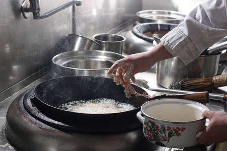 Close up of working chef preparing chinese food, Food frying in wok pan. Sale and food concept 