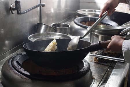 Close up of working chef preparing chinese food, Food frying in wok pan. Sale and food concept の写真素材