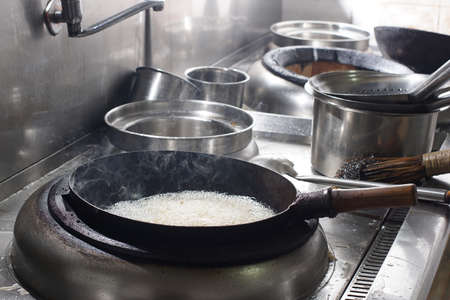 Close up of working chef preparing chinese food, Food frying in wok pan. Sale and food concept 