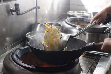 Close up of working chef preparing chinese food, Food frying in wok pan. Sale and food concept の写真素材