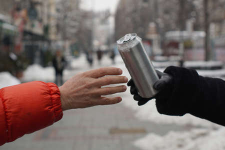 Hand takes the can against the panorama of the cityの写真素材