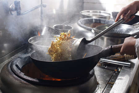 Close up of working chef preparing chinese food, Food frying in wok pan. Sale and food concept 
の写真素材