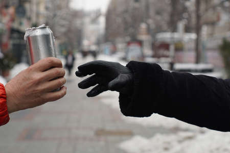 Hand takes the can against the panorama of the cityの写真素材