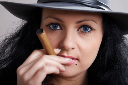An image of woman in the hat smokes cigarsの写真素材