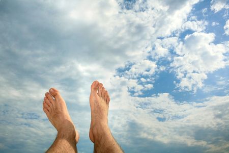 An image of mans feets on background of cloudsの写真素材