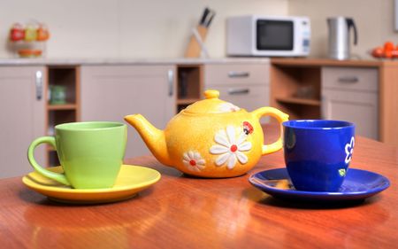 An image of yellow teapot and green and blue teacupsの写真素材