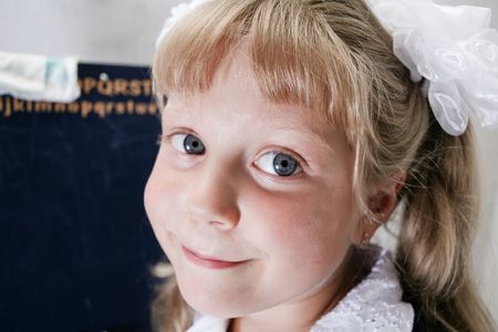 little girl with white bow near the school boardsの写真素材