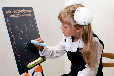 An image of nice little girl in shool writing on chalkboard.の写真素材
