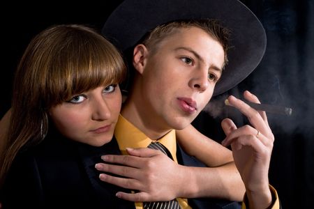 An image of woman and man with cigar in dark room